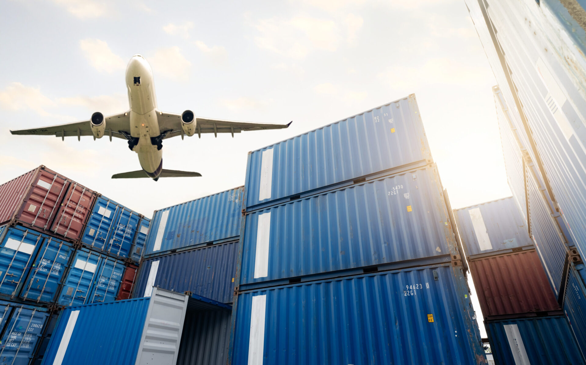 Cargo airplane flying above logistic container