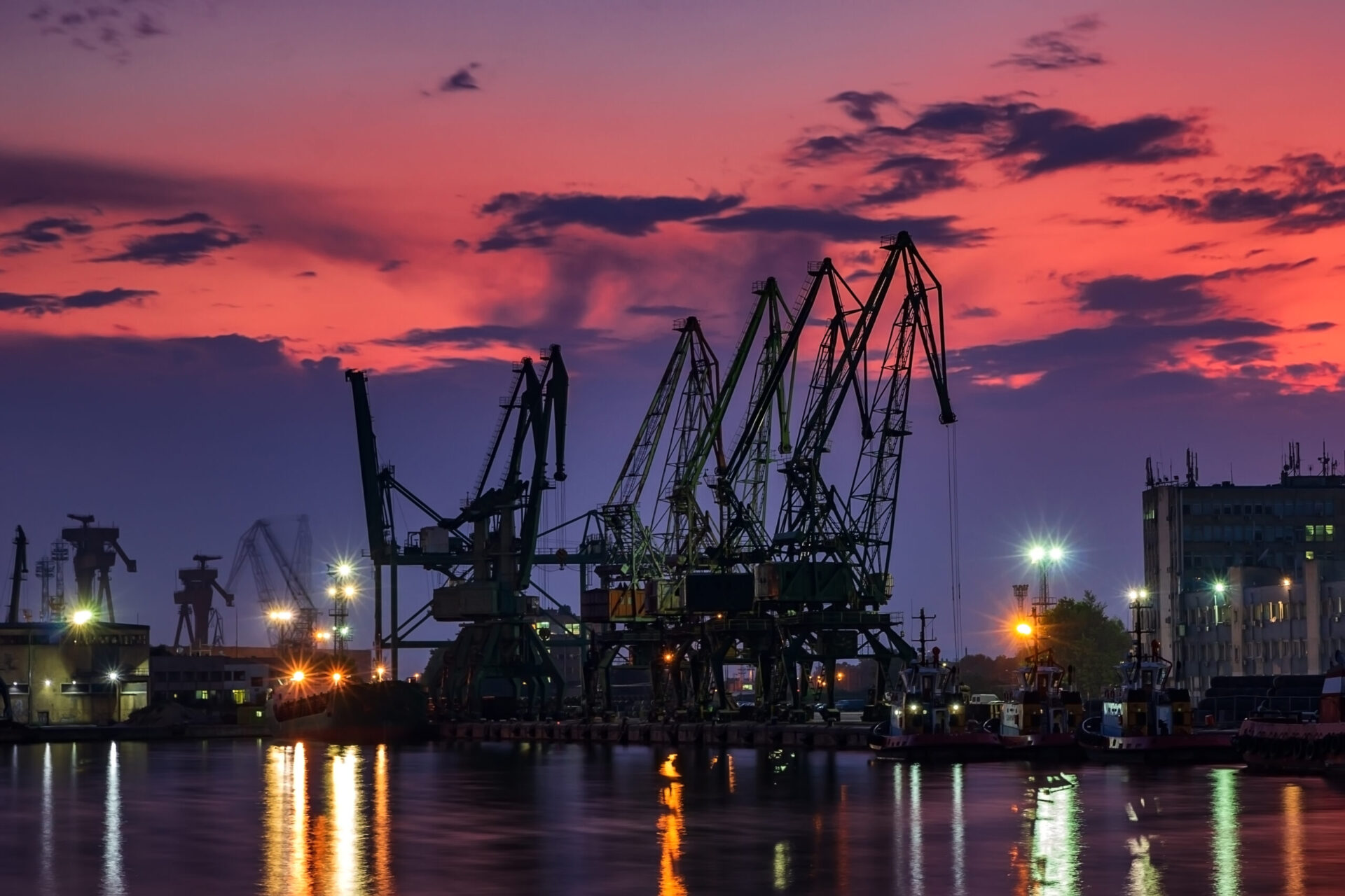 the silhouette of port cranes, at stunning twilight